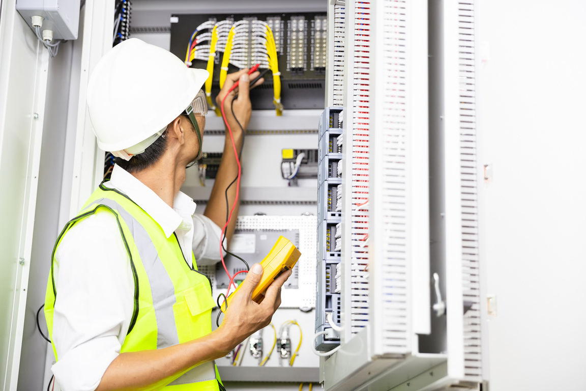 Electrical Engineer Using a Multimeter on a Switchgear