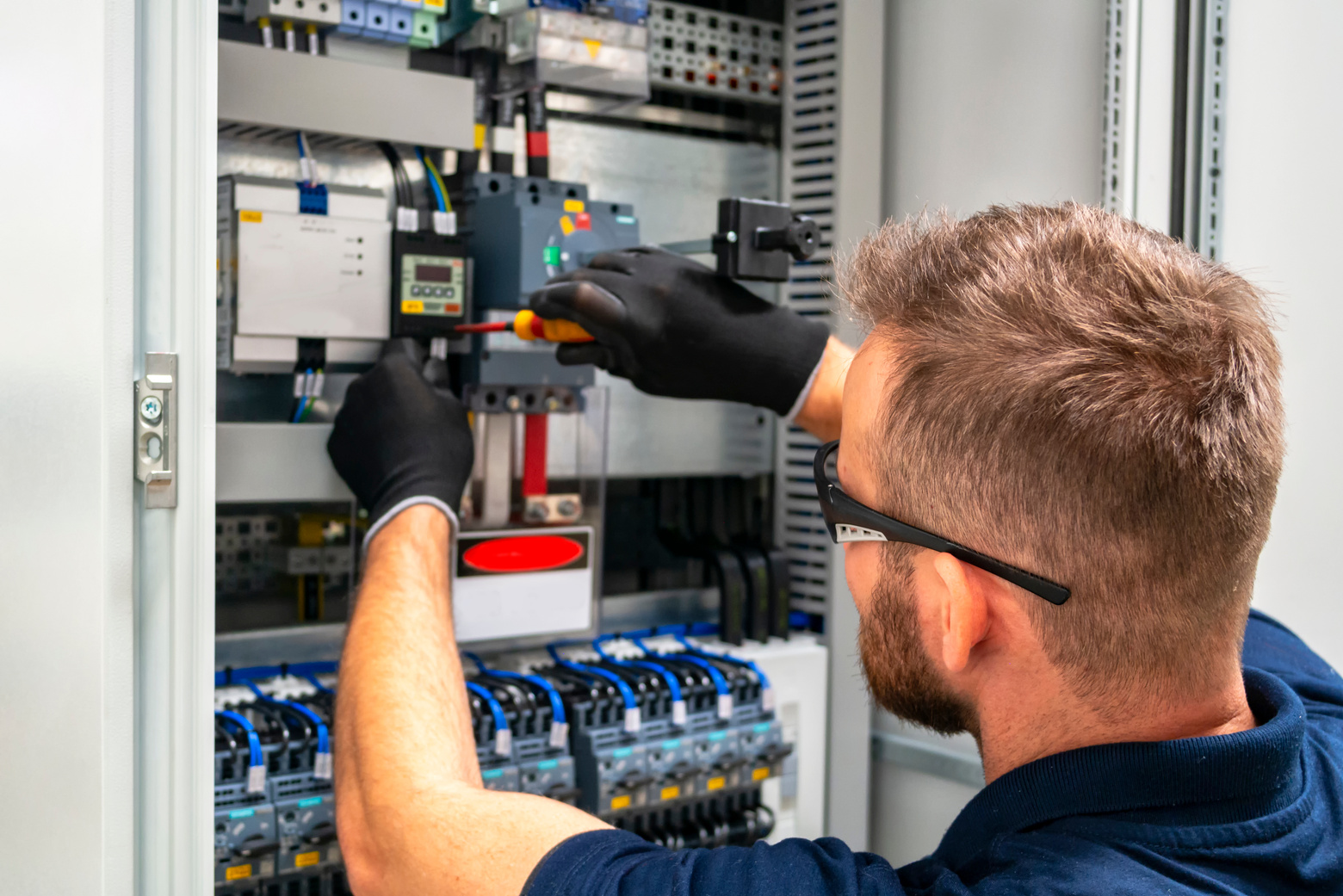 Electrician working at electric panel