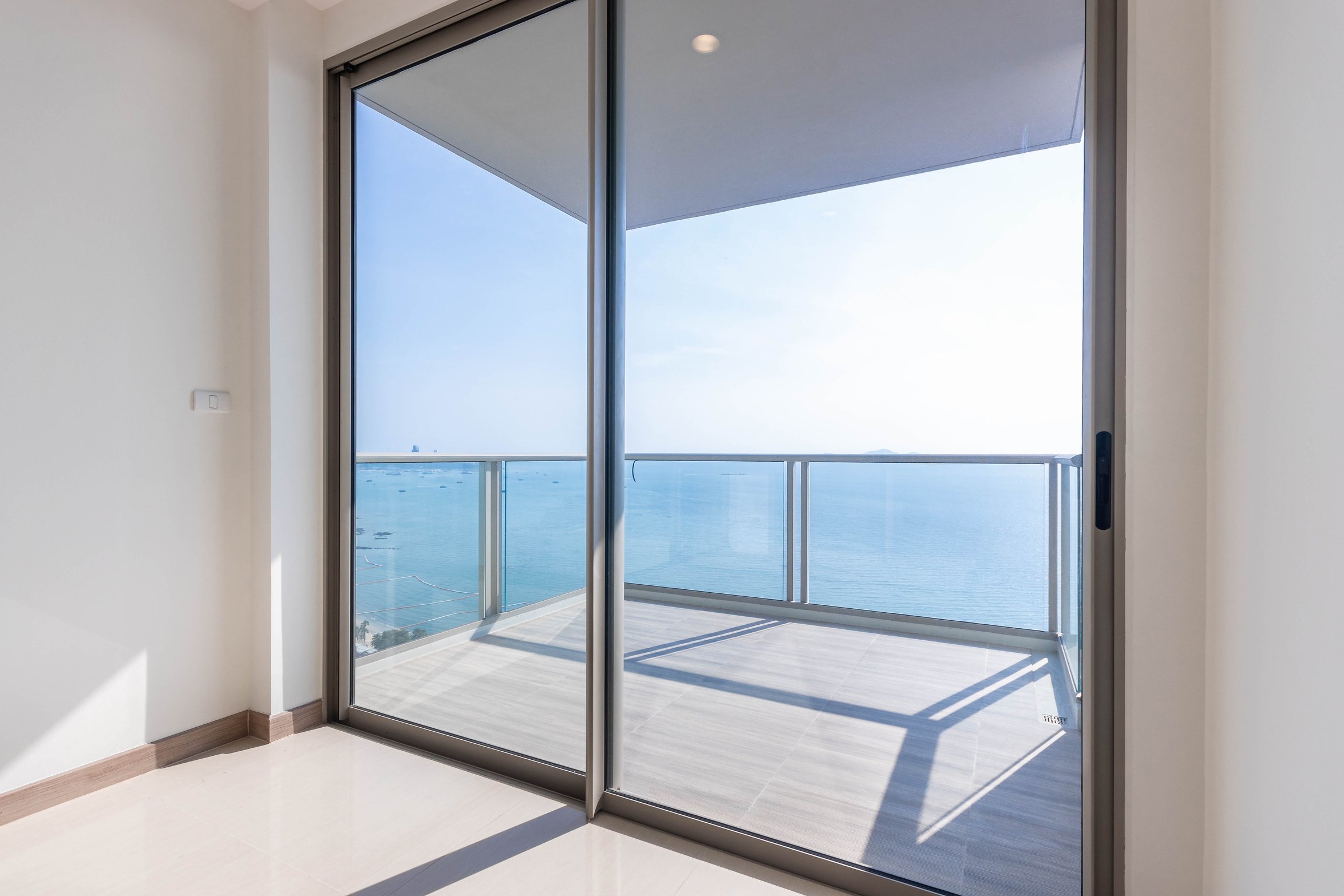 The glass balcony overlooks the sea.
